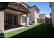 Backyard with artificial turf, a covered patio, and an outdoor dining table at 16425 W Latham St, Goodyear, AZ 85338