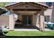 Covered backyard patio with artificial turf, a BBQ, and outdoor lighting at 16425 W Latham St, Goodyear, AZ 85338