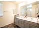 Bright bathroom with a double sink vanity and an extra-large mirror above it at 16425 W Latham St, Goodyear, AZ 85338