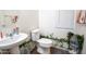 Powder room with a white sink, toilet, and decorative plants, offering a fresh and clean space at 16425 W Latham St, Goodyear, AZ 85338