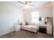 Bedroom with a bed and a vanity area, lit by a decorative fan at 16425 W Latham St, Goodyear, AZ 85338