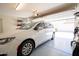 Well-lit garage with storage and a white minivan, providing a clean and functional space for vehicles and belongings at 16425 W Latham St, Goodyear, AZ 85338