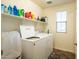 Laundry room with washer and dryer, overhead shelf, and a window at 16425 W Latham St, Goodyear, AZ 85338
