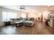 Open-concept living and dining area with a large sectional sofa, tile flooring, and ample natural light at 16425 W Latham St, Goodyear, AZ 85338