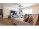 Comfortable living room featuring a large sectional sofa, ceiling fan, and tile flooring at 16425 W Latham St, Goodyear, AZ 85338