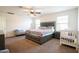 Main bedroom featuring a king bed, ceiling fan, and a bright natural light at 16425 W Latham St, Goodyear, AZ 85338