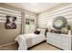 Inviting bedroom with striped accent wall, bright window, and contemporary decor, offering a comfortable and chic space at 18231 W Soft Wind Dr, Surprise, AZ 85387