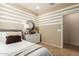 Stylish bedroom featuring a neutral palette, striped accent wall, and modern decor, creating a serene atmosphere at 18231 W Soft Wind Dr, Surprise, AZ 85387