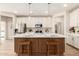 Bright kitchen features an island with seating, stylish pendant lights, white cabinets, and stainless steel appliances at 18231 W Soft Wind Dr, Surprise, AZ 85387