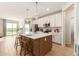 Modern kitchen features a large island with seating, pendant lighting, white cabinetry, and stainless steel appliances at 18231 W Soft Wind Dr, Surprise, AZ 85387