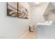 Bright laundry room with modern appliances, artwork, wood-look tile flooring, and storage shelving at 18231 W Soft Wind Dr, Surprise, AZ 85387