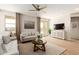 Comfortable living room with sofas, area rug, ceiling fan, and a decorative console beneath a wall-mounted television at 18231 W Soft Wind Dr, Surprise, AZ 85387