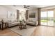 Bright living room boasts tile floors, neutral walls, comfortable seating, and access to the backyard at 18231 W Soft Wind Dr, Surprise, AZ 85387
