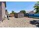 Backyard featuring gravel landscaping, a utility shed, privacy walls, and a peek of the neighbor's roof at 18319 W Marshall Ave, Litchfield Park, AZ 85340