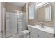 Bright bathroom features a glass-enclosed shower, vanity, modern mirror, and a tile floor at 18319 W Marshall Ave, Litchfield Park, AZ 85340