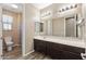 Bright bathroom featuring double sinks, generous vanity, large mirror and separate toilet room at 18319 W Marshall Ave, Litchfield Park, AZ 85340