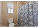 Bathroom with standard toilet and shower with patterned curtain at 18319 W Marshall Ave, Litchfield Park, AZ 85340
