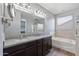 Well-lit bathroom with a double sink, granite countertops, and separate tub and shower at 18319 W Marshall Ave, Litchfield Park, AZ 85340