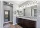Elegant bathroom featuring double sinks with granite counters and dark wood cabinets at 18319 W Marshall Ave, Litchfield Park, AZ 85340
