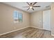 Cozy bedroom featuring light filled window, ceiling fan and wood-look flooring at 18319 W Marshall Ave, Litchfield Park, AZ 85340