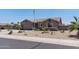 Charming home with neat desert landscaping, a two-car garage, and a proudly displayed American flag at 18319 W Marshall Ave, Litchfield Park, AZ 85340