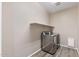 Well-lit laundry room with modern washer and dryer set and convenient shelf at 18319 W Marshall Ave, Litchfield Park, AZ 85340