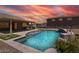Inviting backyard pool and patio area with outdoor kitchen, perfect for entertaining and relaxation with a stunning sunset at 18319 W Marshall Ave, Litchfield Park, AZ 85340
