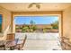 Covered patio with seating and a relaxing view of the landscaped backyard at 189 N Rainbow Way, Casa Grande, AZ 85194