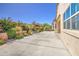 Concrete patio with rock gardens and lush landscaping along the property line at 189 N Rainbow Way, Casa Grande, AZ 85194