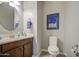 Charming powder room featuring a round mirror, stylish vanity, and a framed print on the wall at 189 N Rainbow Way, Casa Grande, AZ 85194