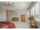 Bright bedroom with a ceiling fan, tile floors, large windows with plantation shutters, and vintage-style furniture at 189 N Rainbow Way, Casa Grande, AZ 85194