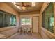 Cozy covered patio features a ceiling fan, seating, and large windows providing plenty of natural light at 189 N Rainbow Way, Casa Grande, AZ 85194