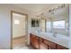 A well-lit bathroom featuring double sinks and a view into the walk-in closet at 19321 N Tara Lane Ln, Maricopa, AZ 85138