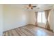 This bedroom has light walls, decorative window coverings, wood-look floors and ceiling fan at 19321 N Tara Lane Ln, Maricopa, AZ 85138