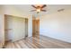This bedroom features wood-look floors, a ceiling fan, and an open closet at 19321 N Tara Lane Ln, Maricopa, AZ 85138