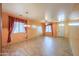 Bright living room with tile flooring, two windows, ceiling fan, and decorative curtains at 19321 N Tara Lane Ln, Maricopa, AZ 85138