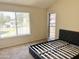 Bedroom with carpet and black platform bed frame and view of pool area at 19601 N 7Th St Ave # 1036, Phoenix, AZ 85024