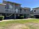 Low-rise apartment building with dark gray exterior, second story balconies and green lawn at 19601 N 7Th St Ave # 1036, Phoenix, AZ 85024