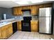Kitchen with wood cabinets, black appliances and tile floors at 19601 N 7Th St Ave # 1036, Phoenix, AZ 85024