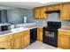 Kitchen with wood cabinets, black appliances and tile floors at 19601 N 7Th St Ave # 1036, Phoenix, AZ 85024