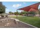 Large backyard featuring a shade structure, trampoline, and custom firepit providing ample space for outdoor activities at 21131 E Excelsior Ave, Queen Creek, AZ 85142