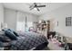 Bright bedroom featuring a ceiling fan, a cozy bed with blue patterned bedding, and ample storage shelves at 21131 E Excelsior Ave, Queen Creek, AZ 85142