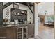 Coffee bar boasts custom chalkboard, beverage fridge, floating shelves, and views to the adjacent living room at 21131 E Excelsior Ave, Queen Creek, AZ 85142