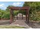 Charming walkway through lush greenery with a decorative pergola, leading to a gate for a private, serene escape at 21131 E Excelsior Ave, Queen Creek, AZ 85142