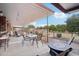 A covered patio with outdoor furniture overlooking the spacious, fenced backyard at 21131 E Excelsior Ave, Queen Creek, AZ 85142