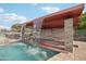 Backyard covered bar area with cascading waterfall feature adds luxury to the outdoor space at 21131 E Excelsior Ave, Queen Creek, AZ 85142