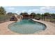 Relaxing backyard pool with rock waterfall feature surrounded by a secure safety fence at 21131 E Excelsior Ave, Queen Creek, AZ 85142