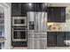 Modern kitchen featuring stainless steel appliances including refrigerator, oven, and microwave, complemented by dark cabinetry at 2148 W Angelo Way, San Tan Valley, AZ 85144