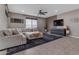 Cozy living room with a sectional sofa, neutral tones, a ceiling fan, and plenty of natural light at 2148 W Angelo Way, San Tan Valley, AZ 85144