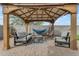 Relaxing backyard patio with a covered pergola, comfortable seating, and a calming hammock for outdoor enjoyment at 2148 W Angelo Way, San Tan Valley, AZ 85144